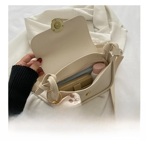 Detailed interior of cream shoulder bag showing storage for phone and wallet