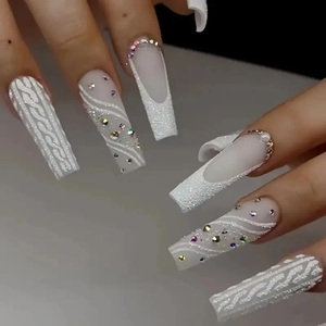 Detail van lange vierkante kunstnagels met witte trui-textuur en strassteentjes