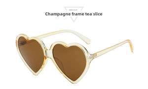 Detail of heart-shaped sunglasses with champagne frames and brown tinted lenses