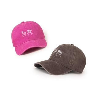 Washed cotton baseball caps in rose pink and dark grey with white skull embroidery