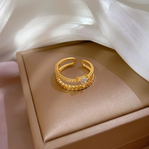 Detail view of gold double-layered adjustable ring with triangle zircon on silk