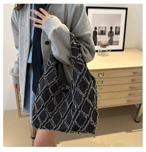 Détail du sac cabas en denim noir avec texture en losanges effilochés sur le mannequin