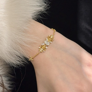 Detail of gold zircon iris flower chain bracelet with vintage fleur-de-lis hollow design