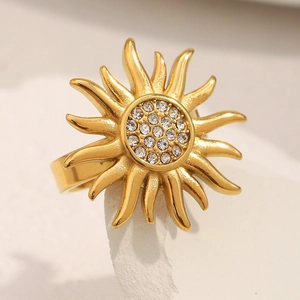 Detail of 18K gold-plated sunburst ring with white zircons on a textured stone stand