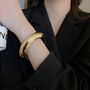 Bracelet jonc large en métal doré poli avec finition miroir pour un look moderne minimaliste