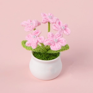 Handmade crochet pink forget-me-not mini potted plant with pearl details and white ceramic base