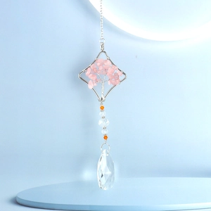Detail of rose quartz tree of life hanging ornament with crystal prism and wire frame