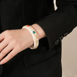 Retro acrylic marble bangle with colorful inset rhinestones on model wrist