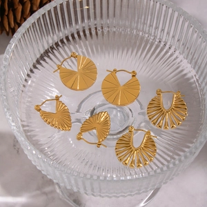 Detailed macro view of three pairs of vintage gold plated hoop earrings in textured styles