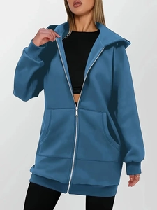 Detail of a blue zip-up hoodie featuring a spacious hood, large front pockets and ribbed cuffs