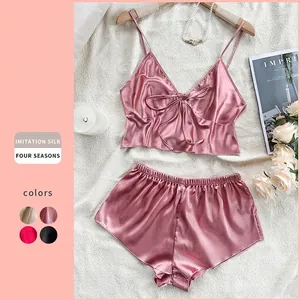 Pink imitation silk pajama set with V-neck camisole and shorts on a stylish flat lay