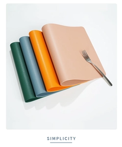 Close-up of stacked colorful waterproof faux leather placemats with a silver fork