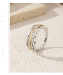 Detail of silver and gold layered ring with sparkling zircons on stone texture