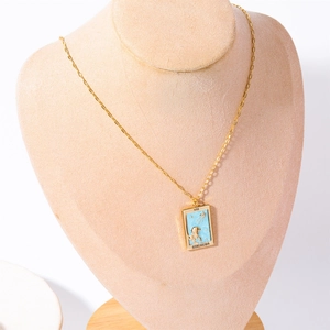 Close-up of golden Tarot Strength pendant necklace with blue inlay on model