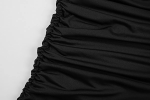 Detail view of the elegant side ruching on a sexy black slim-fit mesh dress