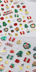 Macro shot of 3D embossed Christmas nail stickers with festive patterns and gold glitter