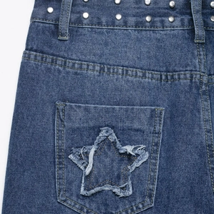 Short en jean bleu tendance avec patchs en forme d'étoile et clous métalliques sur la poche