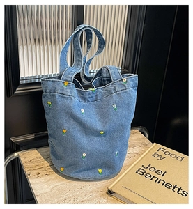 Detail der Tulpenstickerei auf hellblauer Denim-Beuteltasche mit Stoffgriff