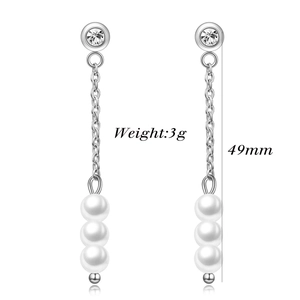 Detail of 49mm long chain earrings featuring white pearls and crystal studs in silver finish