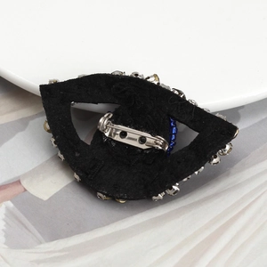 Detailed back view of evil eye brooch showing secure metal safety pin and crystal settings