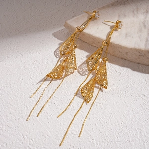 Detailed shot of 18K gold plated tassel earrings with hollow geometric patterns and zircons
