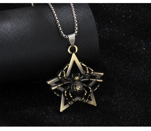 Detail of vintage bronze spider and pentagram pendant on a silver box chain
