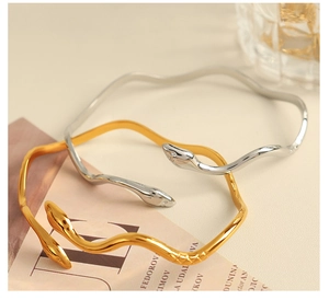 Macro shot of gold and silver snake-shaped bracelets with detailed scale texture