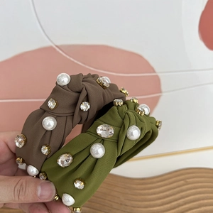 Detailed view of coffee and green fabric headbands with pearl and rhinestone accents