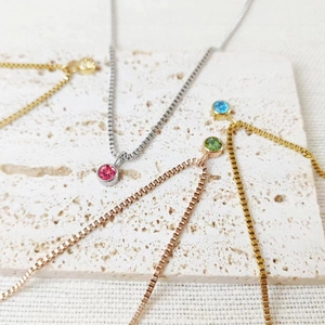 Close-up of titanium steel necklaces with colorful 8mm birthstone crystal pendants