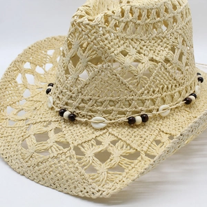 Detailed hollow weave of a straw cowboy hat featuring shell and wooden bead accents