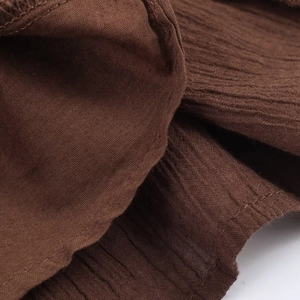 Detail shot of dark brown pleated fabric with breathable cotton linen texture and sewing