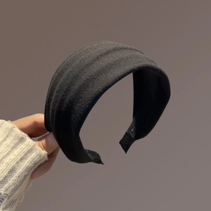Vue détaillée du serre-tête noir rembourré avec une finition en tissu texturé