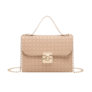 Detailed view of beige crossbody bag with quilted texture and gold metal buckle