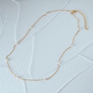 Close-up of elegant S925 silver pearl necklace with delicate gold chain and white pearls