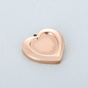 Macro shot of rose gold heart pendant with polished edges and matte center finish