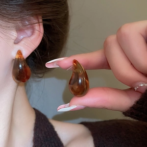 Detailed view of amber resin teardrop earrings worn to show size and translucent finish