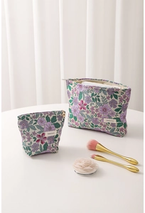 Macro shot of two-piece floral jacquard makeup bags with metallic zippers and elegant texture