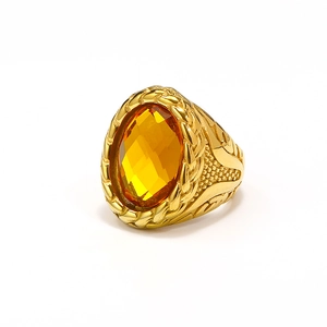 Macro shot of oval amber gemstone and braided texture on gold stainless steel ring