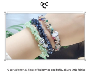 Trois élastiques à cheveux perlés bleu et vert portés comme bracelets décoratifs au poignet