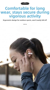 Detailed side view of white ear-clip wireless headphones worn during outdoor exercise