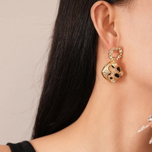 Gros plan de boucles d'oreilles pendantes vintage à imprimé léopard et diamants