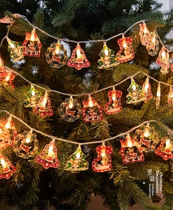 Close-up of LED Christmas string lights with Santa and reindeer ornaments on tree