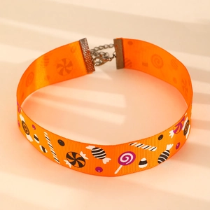 Détail du choker d'Halloween avec ruban orange, motifs bonbons et fermoir en bronze