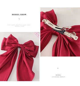 Close-up of the wine red satin bow hair clip with silver metal spring buckle details