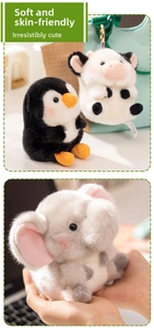 Detail view of plush animal bag charms showing soft fluffy penguin and cow texture
