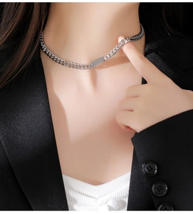 Silver cuban chain necklace with rectangular pendant worn on a black blazer outfit