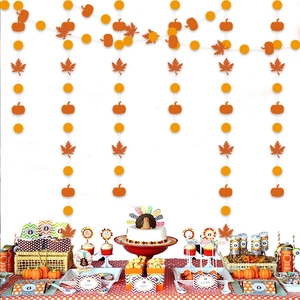 Vertical autumn maple leaf and pumpkin garland hung over a festive party dessert table