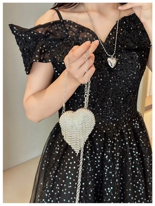 Detailed macro view of heart-shaped evening bag with silver rhinestones and fringe