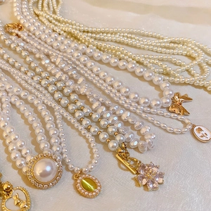 Colliers de perles vintage français avec pendentifs cœur et fleur en or sur tissu