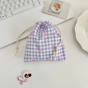 Detail of purple plaid drawstring pouch featuring pink bow patterns on a cotton fabric